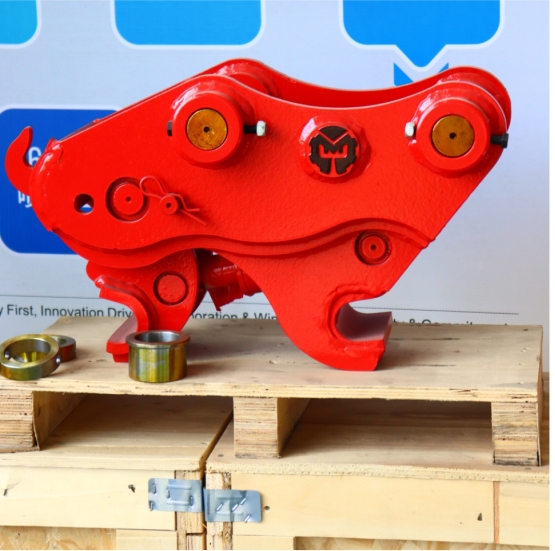 Red hydraulic quick coupler with bushings on wooden pallet for excavator