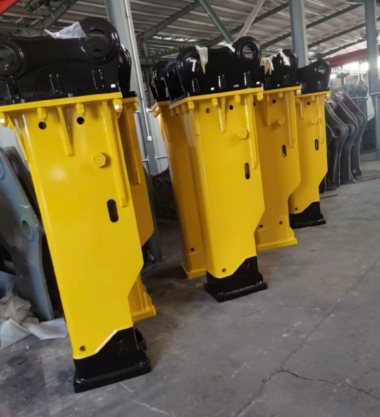 Yellow box-type hydraulic breakers lined up in a workshop